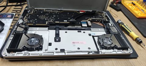 Laptop with the keyboard removed, showing the twin cooling fans