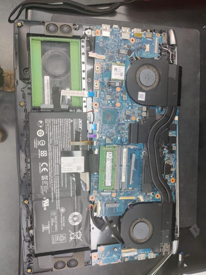 Acer laptop opened on the bench with the battery and cooling fans exposed