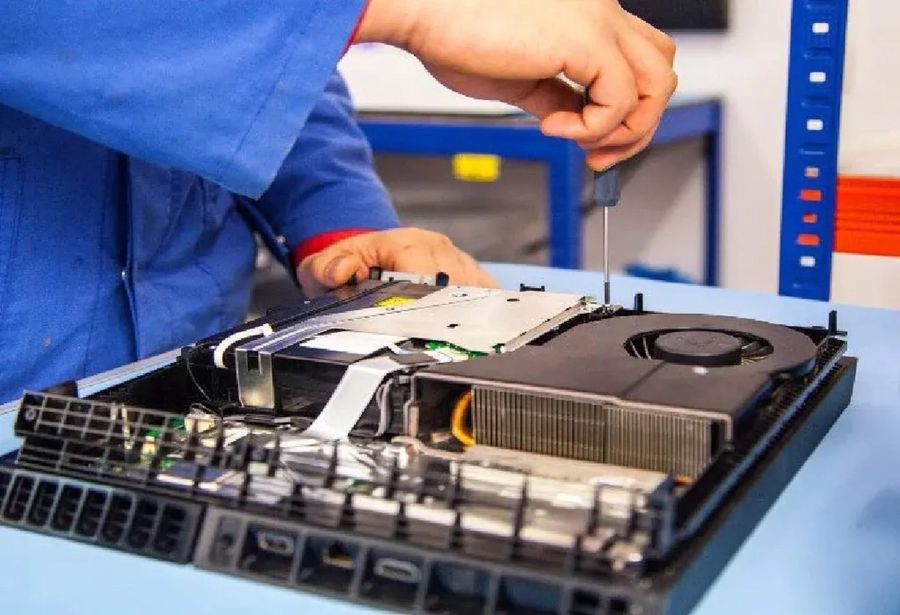 A games console stripped down for a disc drive and cooling fan service