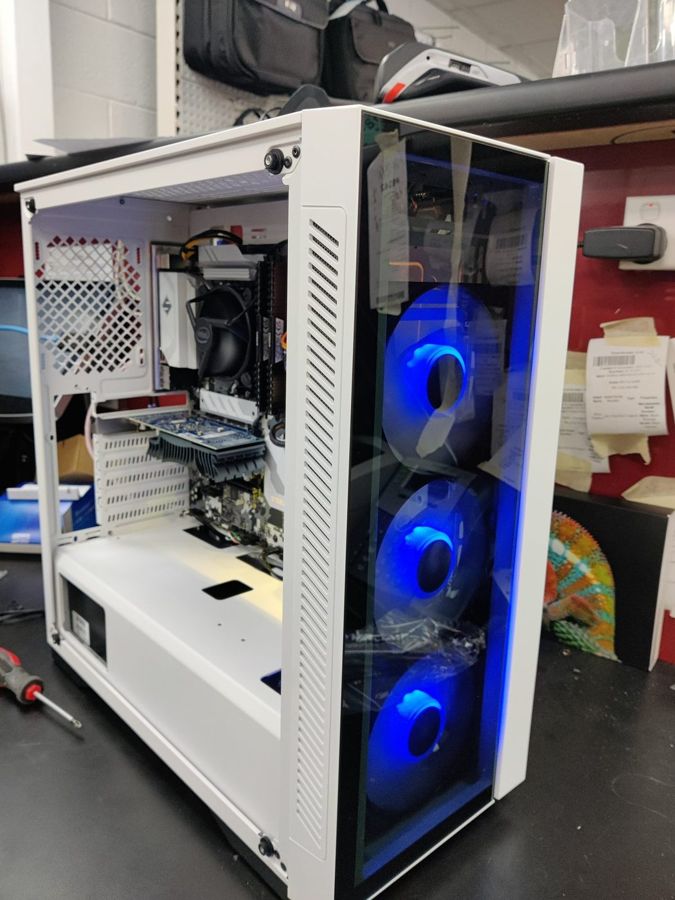 A white custom PC build with blue case fans during assembly